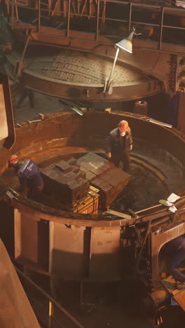 trabajadores del acero cargando lingotes en una fundición