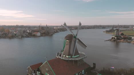 aerial view on windmills in a typical dutch landscape with rotating wicks on a bright day with blue sky