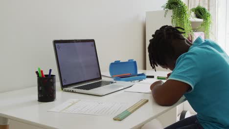 Afroamerikanischer-Junge-Macht-Hausaufgaben-Und-Schaut-Zu-Hause-Auf-Einen-Laptop-Mit-Kopierplatz