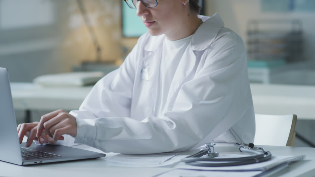 Doctor working on laptop at desk with stethoscope