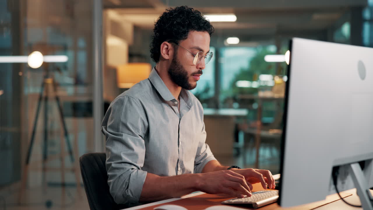 Focused Man Typing on Computer Keyboard in Modern Office