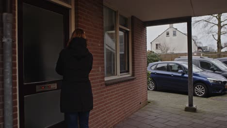 dolly out of woman walking to her front door and entering her house