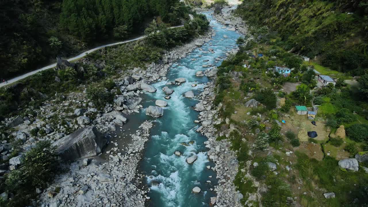 una toma aérea de un dron que muestra a un vehículo atravesando un puente pintoresco mientras el río cristalino fluye por debajo.