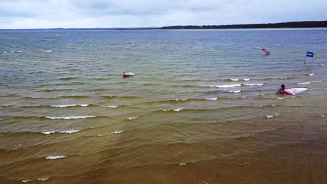 toma aérea de windsurfistas en el ventoso lago biscarrrosse en otoño, sur de francia