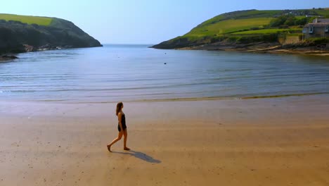 Woman-walking-on-the-beach-on-a-breezy-day-4k