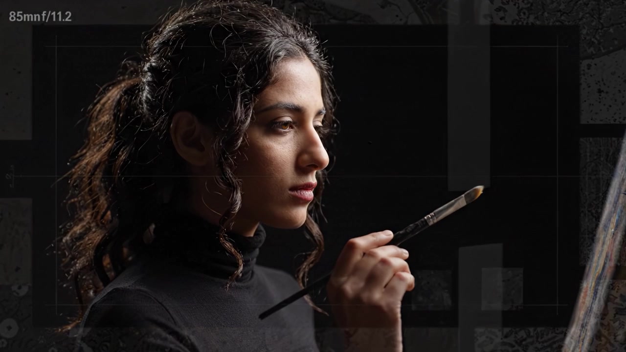 A Contemplative Artist Engaged in Creation: Capturing the Essence of Inspiration and Talent Through the Motion of a Brush on Canvas in a Dramatic Lighting Setting
