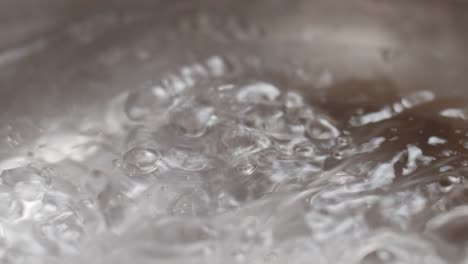 boiling water with bubbles in pan