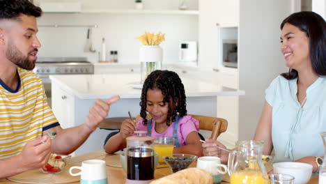 family enjoying breakfast together at home, sharing conversation and smiles