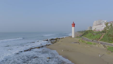 umhlanga lighthouse and coastline with waves crashing on beach, durban, south africa, daytime, aerial view