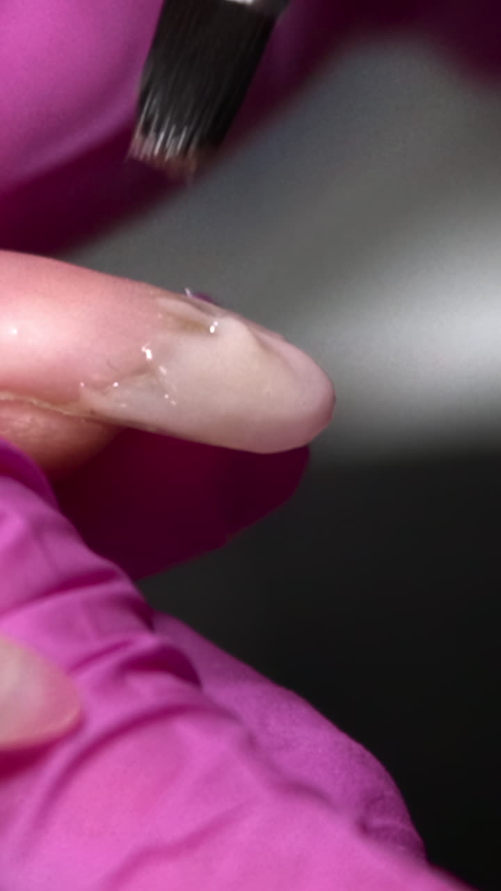 Close-up of Nail Technician Applying Gel to Fingernail