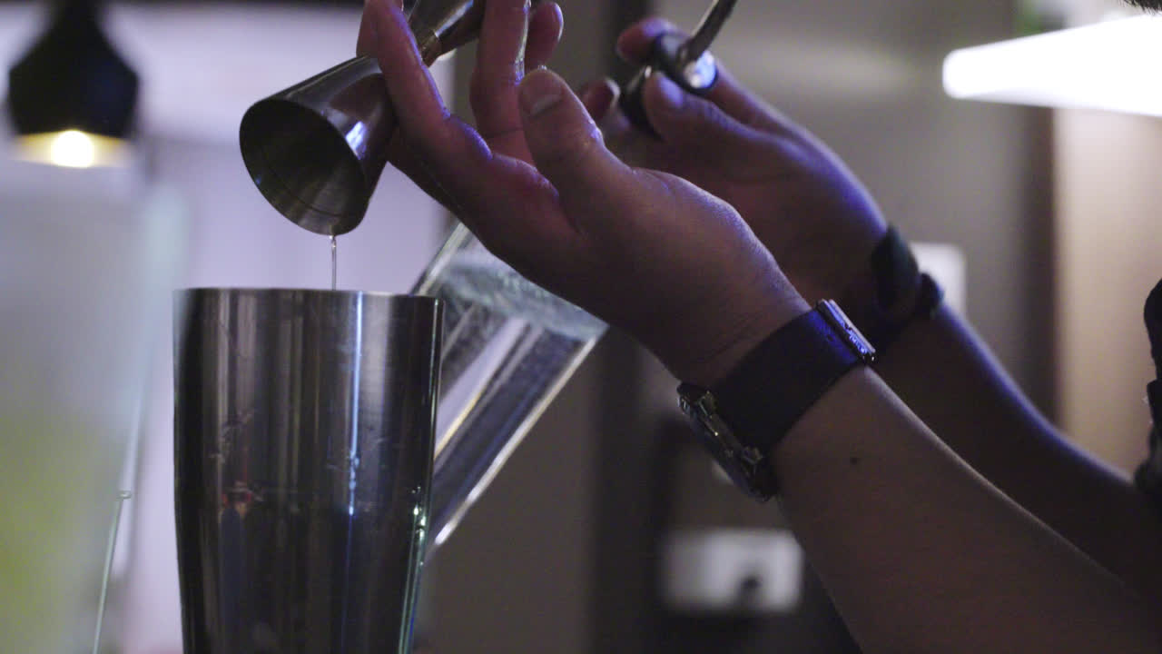 Close-up of a bartender pouring ounces of drink