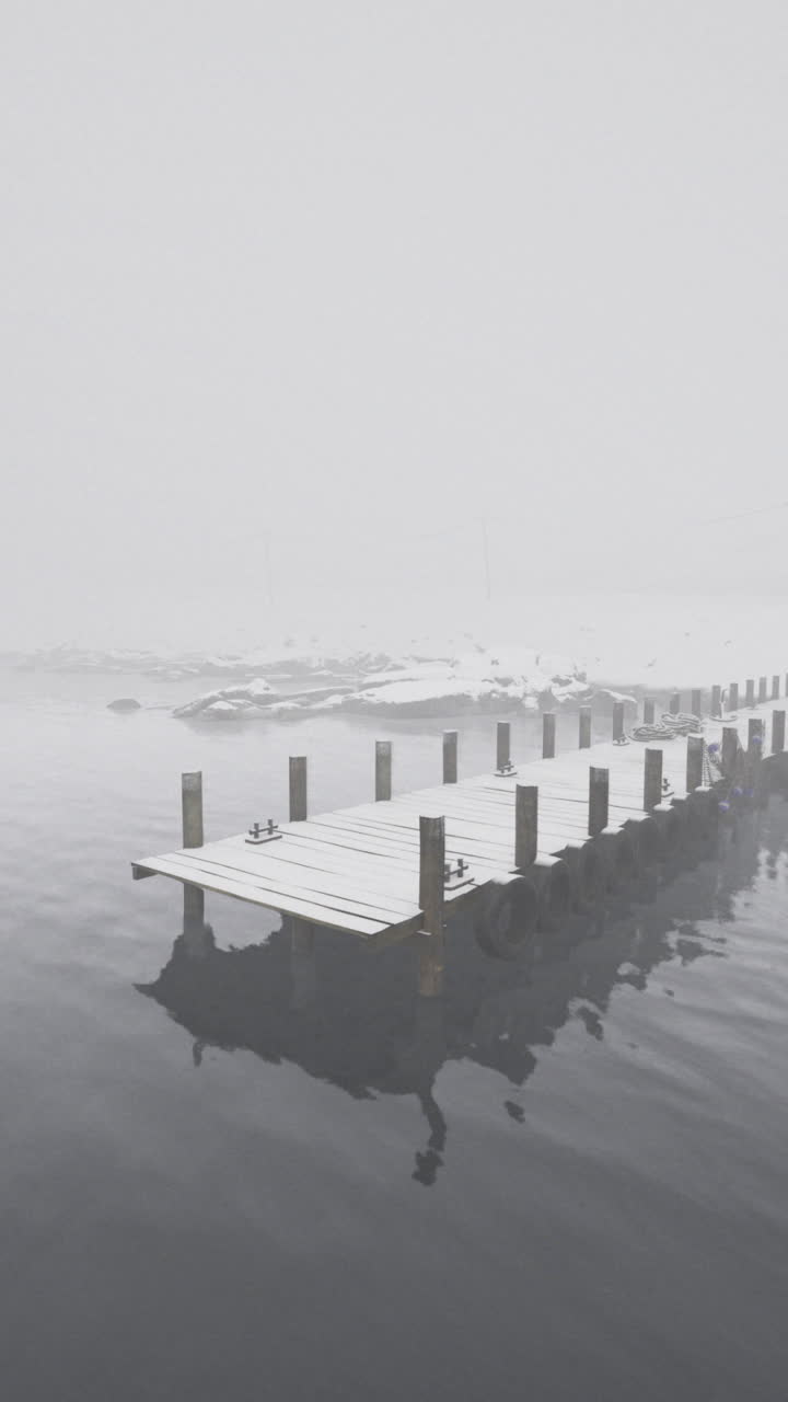 Tranquil winter morning at a foggy lakeside dock with a cozy cabin