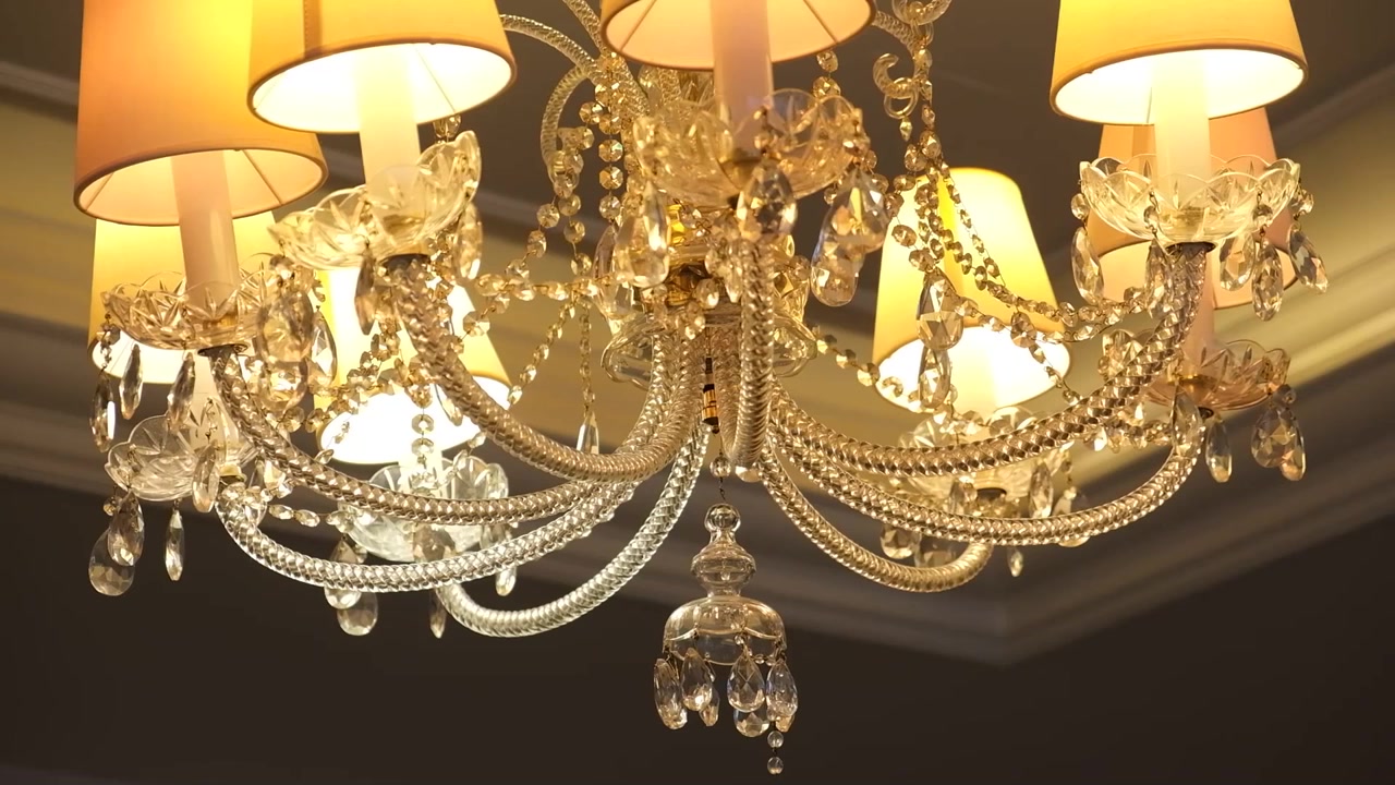 Close-up of a luxurious crystal chandelier with soft, warm lighting.