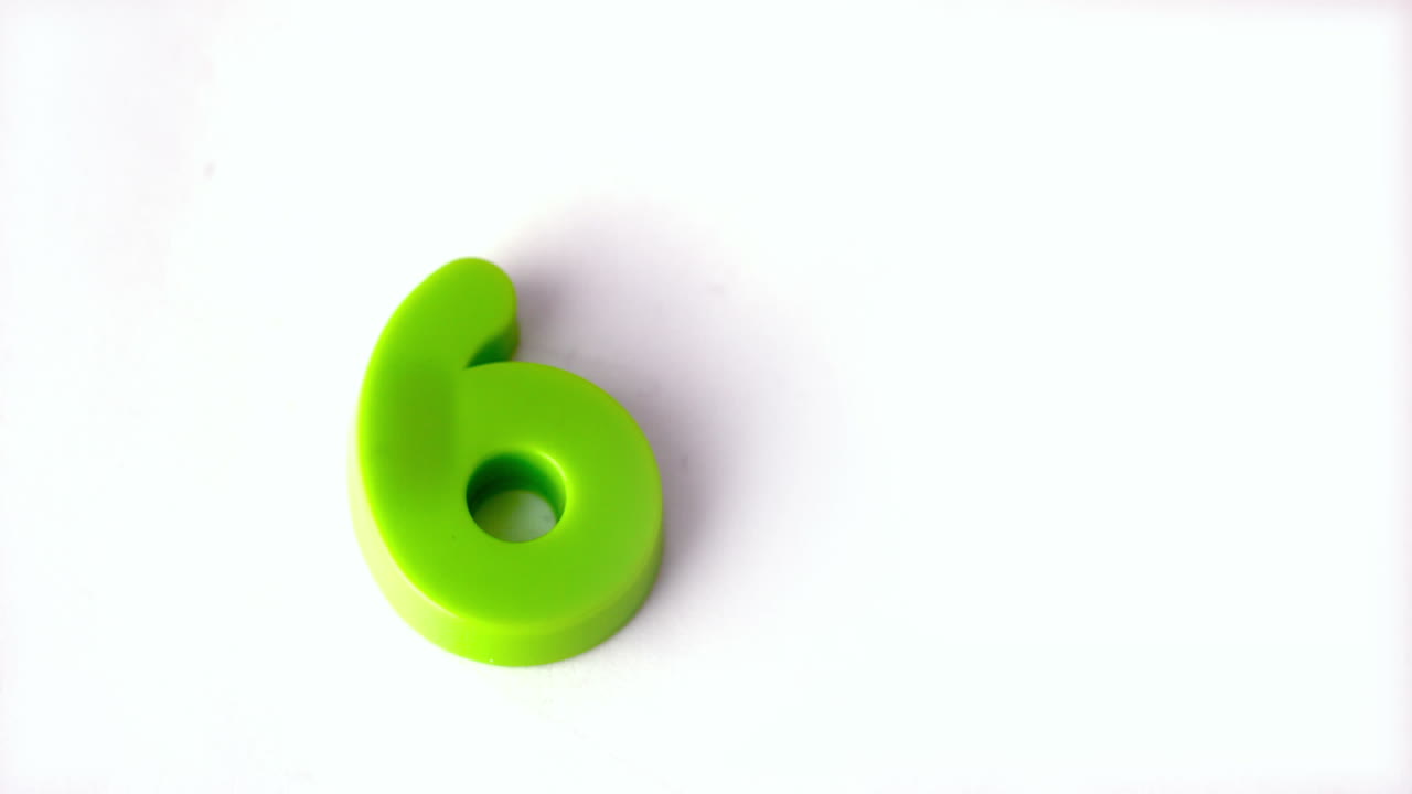 Number six falling onto white surface