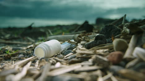 一瓶瓶子在沙灘上躺在其他垃圾中間的浅焦射擊