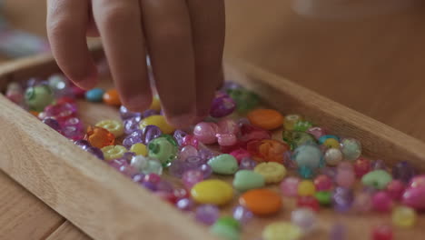 child playing with colorful beads