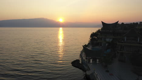 drone flyover of waterfront resorts on samosir island on lake toba in north sumatra, indonesia at sunrise