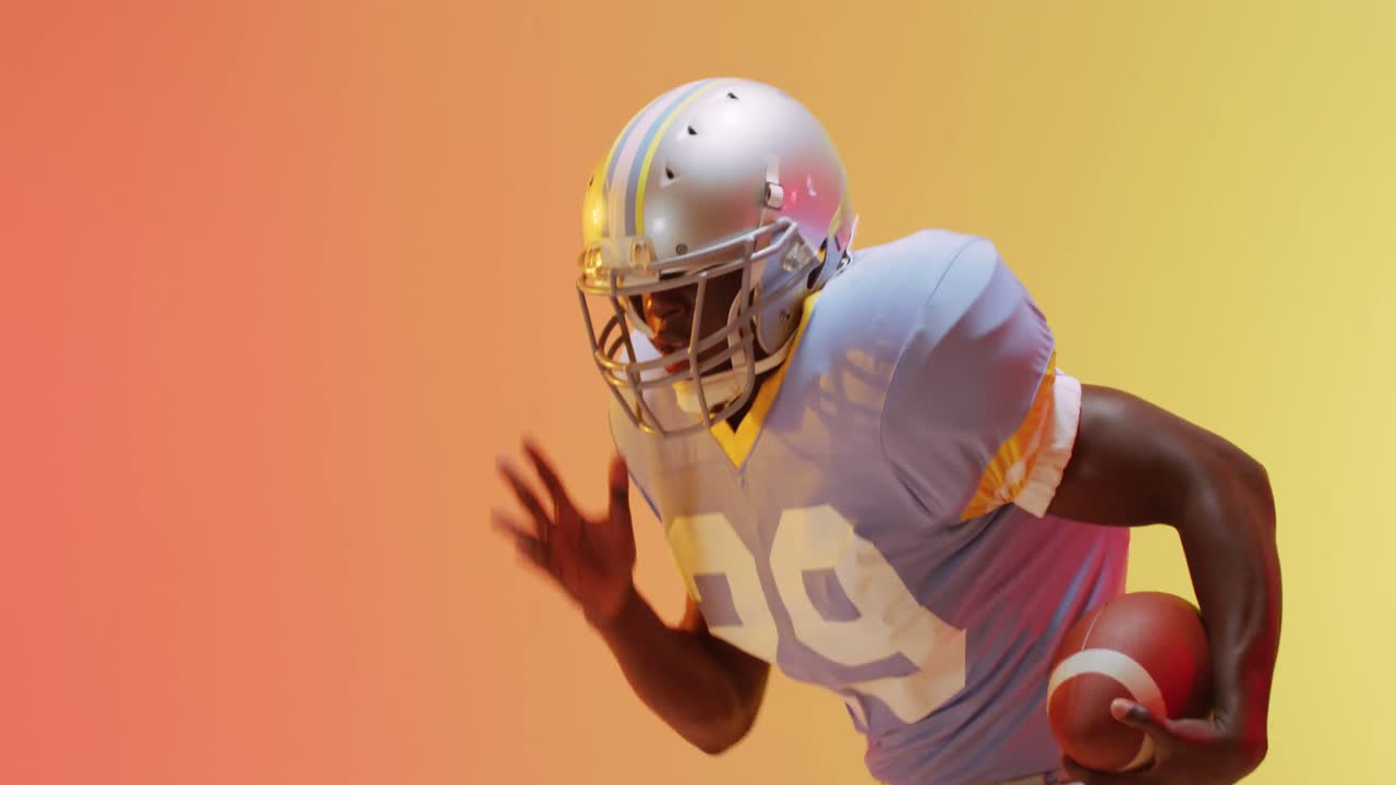 Video di un giocatore di football americano afroamericano con pallone su sfondo giallo-arancione.