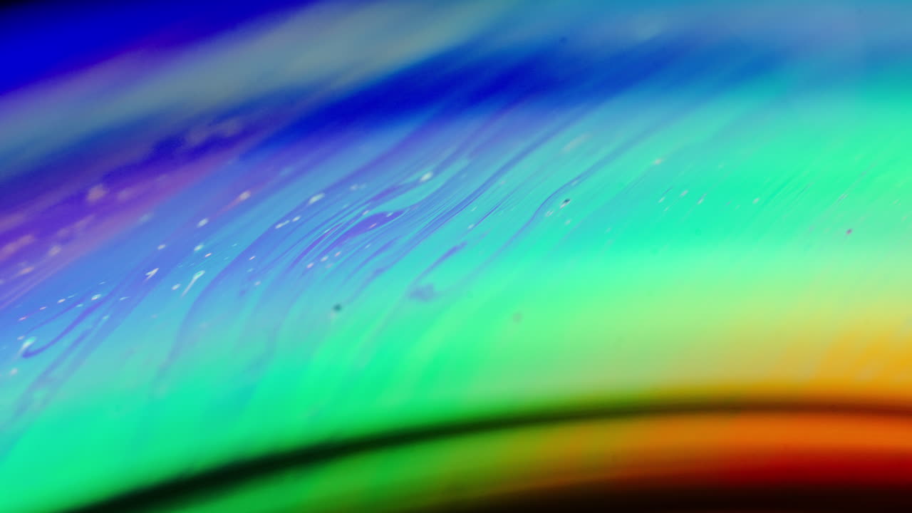 Abstract macro shot of swirling, colorful light reflections creating a dreamy, fluid pattern