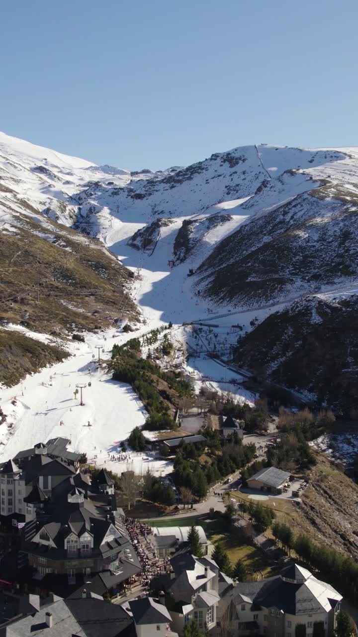 Sierra Nevada kayak merkezinin beyaz karla kaplı halinin dikey havadan drone çekimi