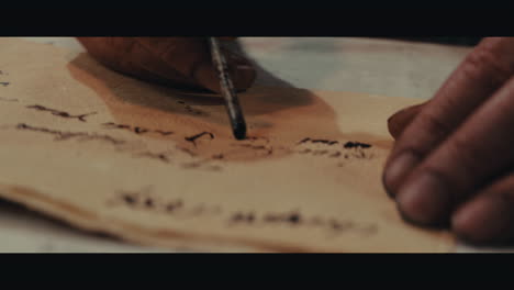 an old captain sits writes a letter inside the sailing ship cabin