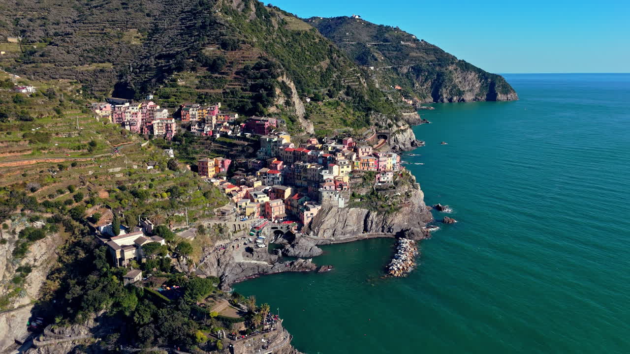 Colorful village of Manarola on cliffs, sunny coastline, Mediterranean view