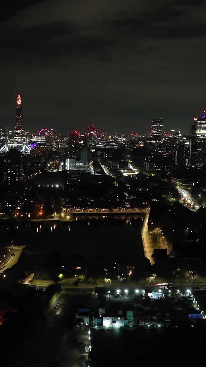 Portrait aerial of the Shadwell basin and the night lit skyline of London, UK