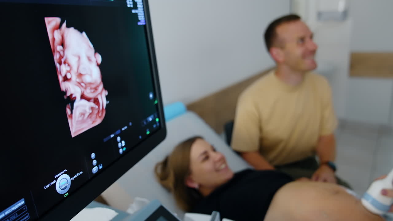 Immagine 3D di un bambino non ancora nato sullo schermo nero di un'ecografia. Futuri genitori felici in secondo piano sfocato.