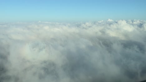 El-Punto-De-Vista-De-Un-Piloto:-Volando-Hacia-Las-Nubes-Para-Cruzar-Algunas-Nubes-Esponjosas-Durante-El-Descenso,-Con-La-Sombra-Del-Jet-Por-Delante