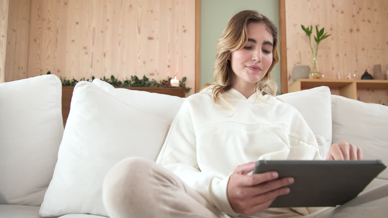 Christmas time, Relaxing on cozy sofa, woman using tablet in warm, festive living room, copy space
