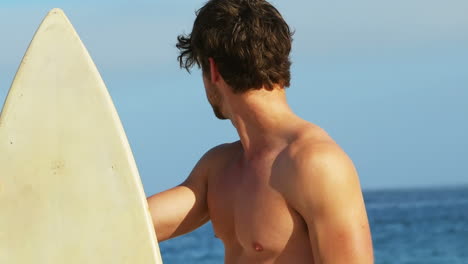 hombre sonriente con una tabla de surf