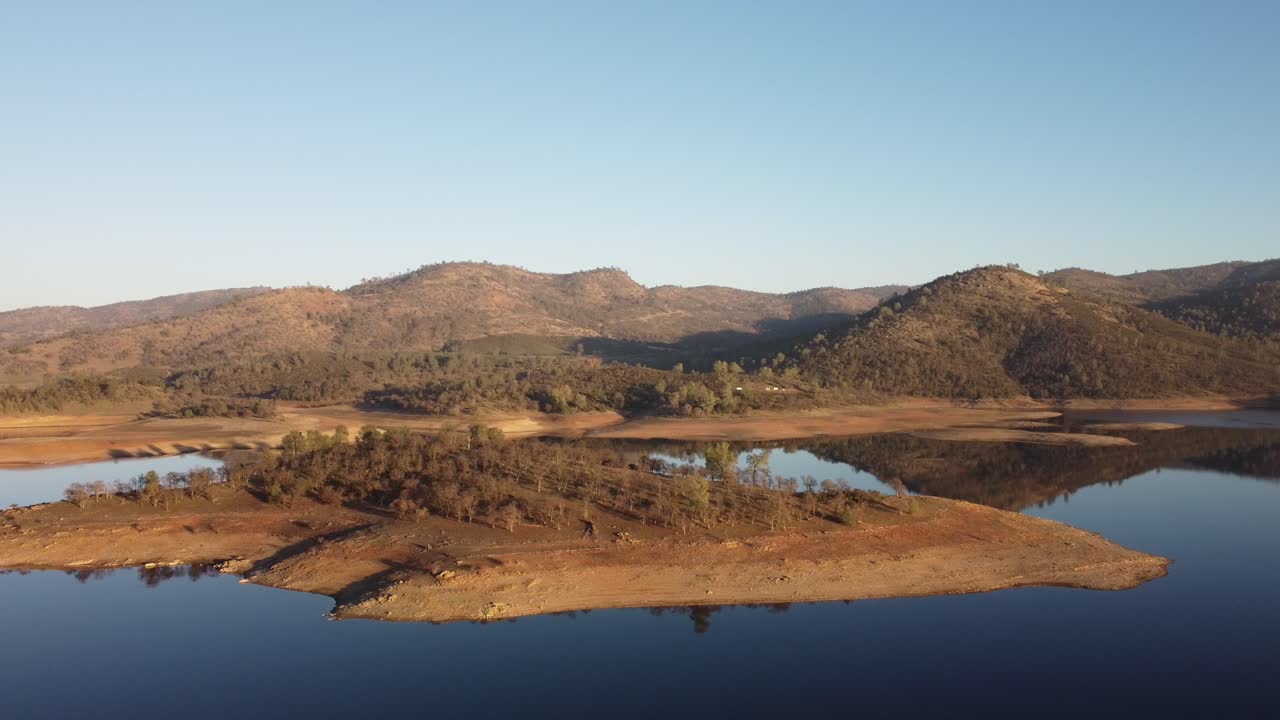 The contrast of deep blue water and earthy terrain unfolds in this aerial perspective of New Hogan Lake.