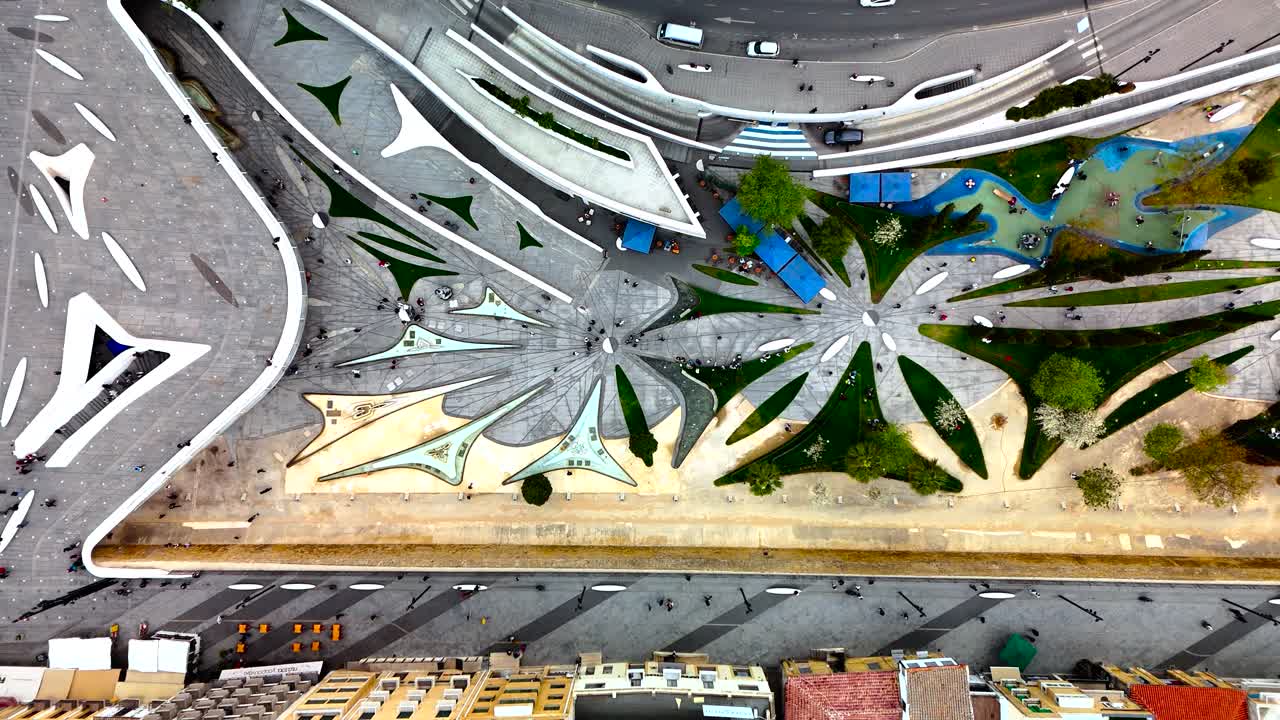 Discover an aerial perspective of a contemporary park filled with flower-like designs. Bright green spaces and pathways invite visitors for leisurely walks and relaxation