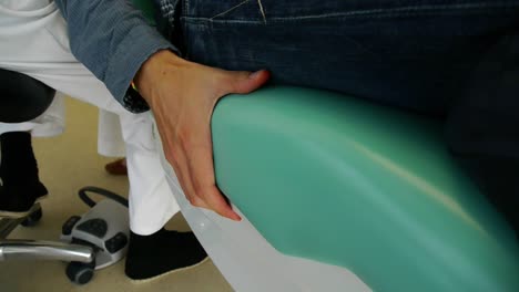 el paciente yace nerviosamente en una silla dental y sufre dolor