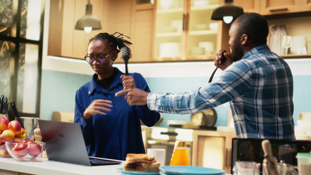 pareja cantando y bailando en la cocina