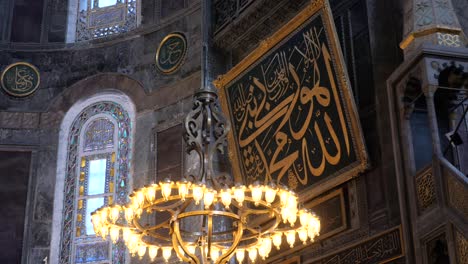 interior of a mosque with arabic calligraphy and a chandelier