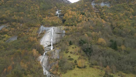 The-brengfossen-waterfall-in-norway-surrounded-by-autumn-foliage,-aerial-view