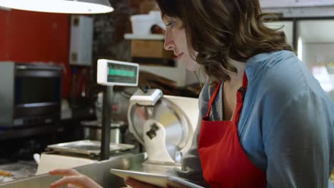 female baker using digital tablet in bakery shop 4k