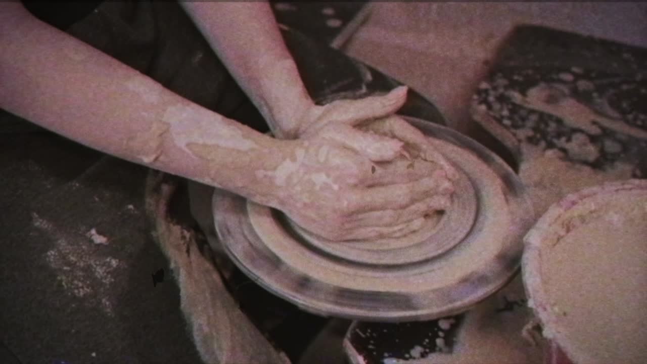 un alfarero enseña a una mujer a hacer platos de arcilla. un hombre toma las manos de una mujer. efecto vintage.