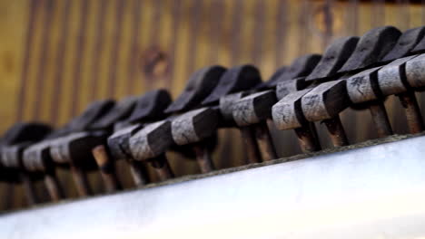 old broken hammers of a deteriorated and abandoned piano, panning close up