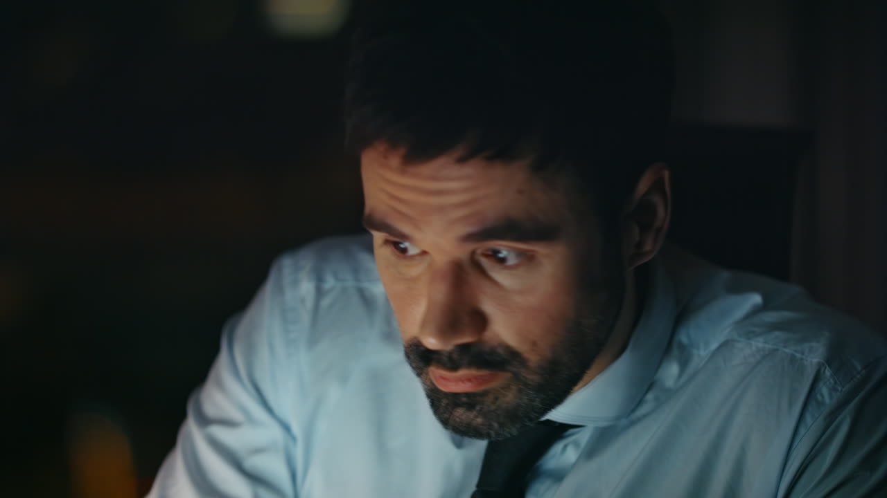 trabajador de horas extras bebiendo café sentado en una oficina oscura de cerca. adicto al trabajo trabajando