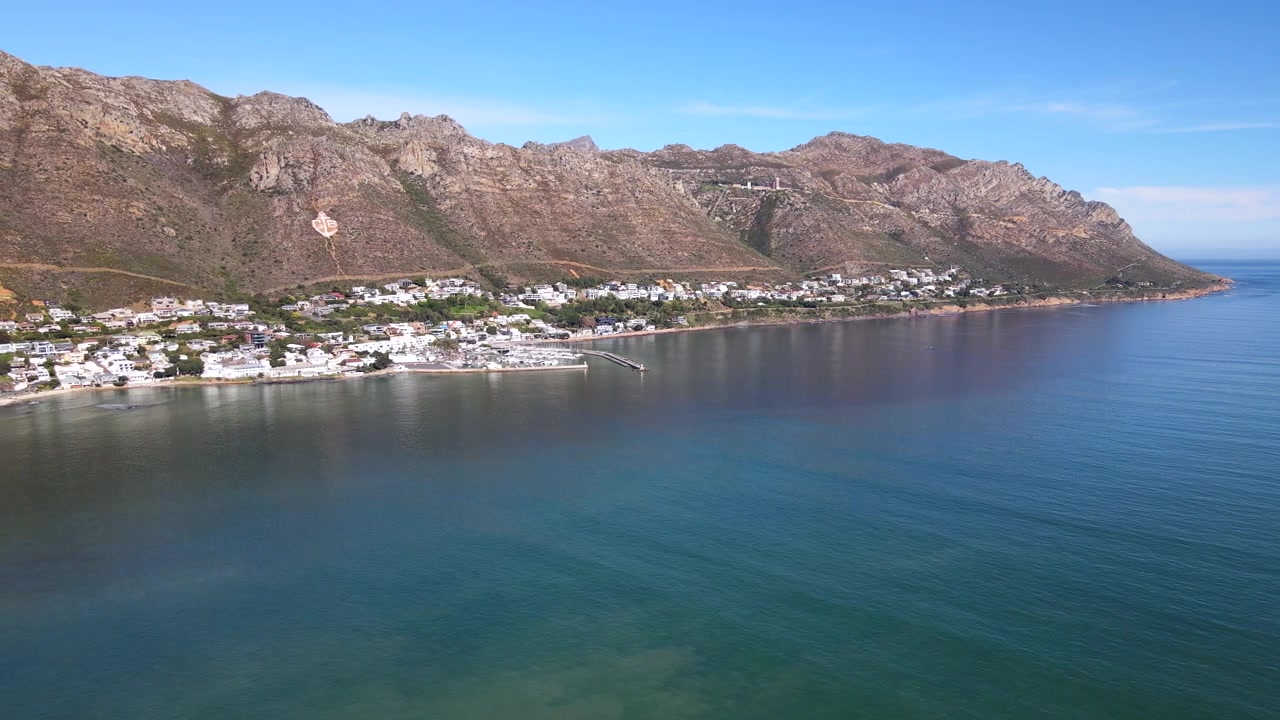 Pittoresca città portuale costiera di Gordon's Bay sotto la montagna, ampia vista aerea