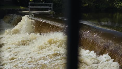 Agua-De-Río-En-Cámara-Lenta-Corriendo-Sobre-Una-Presa,-Agua-Corriendo-Creando-Olas-Sobre-Una-Escalera-De-Peces