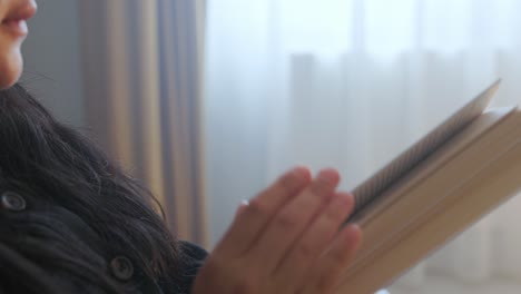 Woman-Sitting-Indoor-Reading-Book---Close-Up