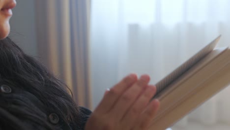 mujer sentada en el interior leyendo un libro - de cerca