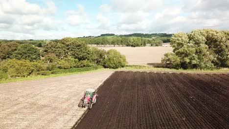 aerial footage over tractor ploughing field