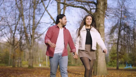 a husband and wife walking through a park in port coquitlam