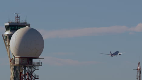 airplane taking off near air traffic control tower