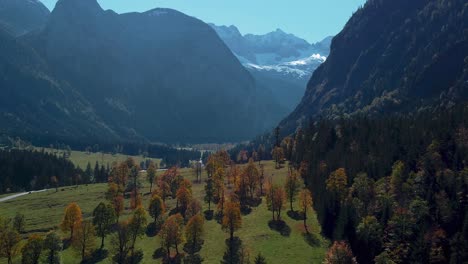 Colorful-maple-trees-with-red-and-yellow-fall-leaves-in-sunny-vibrant-autumn-in-the-alps-mountains-in-Tyrol,-Austria-at-scenic-Ahornboden-tourist-travel-spot