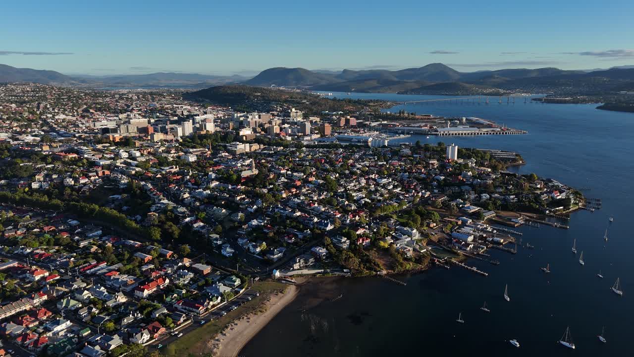 Harbor of Hobart city with mountains in background in Tasmania, drone shot high altitude
